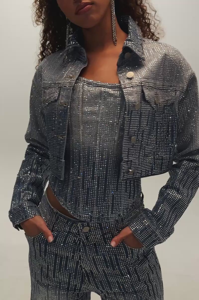 Video of woman modeling the MIND SPINNING EMBELLISHED DENIM CORSET and matching denim pants, both adorned with sparkly rhinestones. 