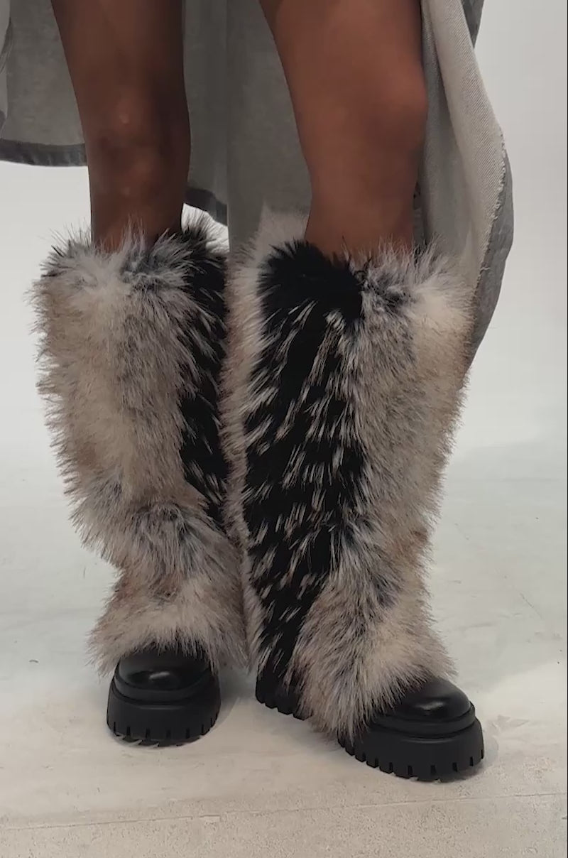 Video of woman modeling the AZALEA WANG SAUGHETTE BROWN MULTI FUR COMBAT BOOT, featuring tall, knee-high faux fur in black, tan, and white tones with chunky black soles