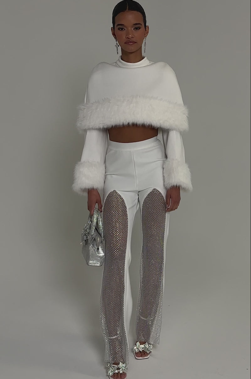 Video of woman modeling the PALMER BANDAGE TROUSER WITH RHINESTONE MESH, silver heels, and a sparkling clutch.