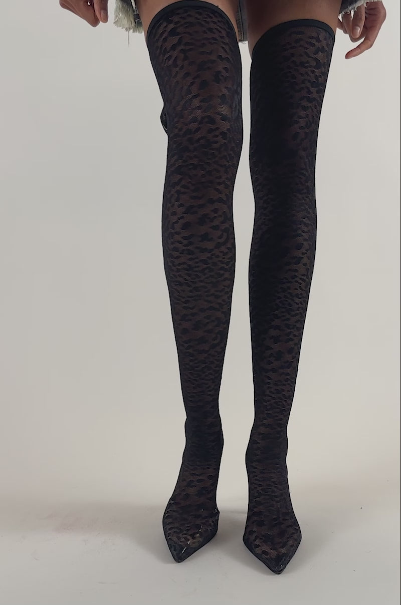 Video of a woman modeling the AZALEA WANG NEW FREYJA BLACK LEOPARD LACE STILETTO THIGH HIGH boots—sleek, black leopard-print thigh highs with pointed heels.