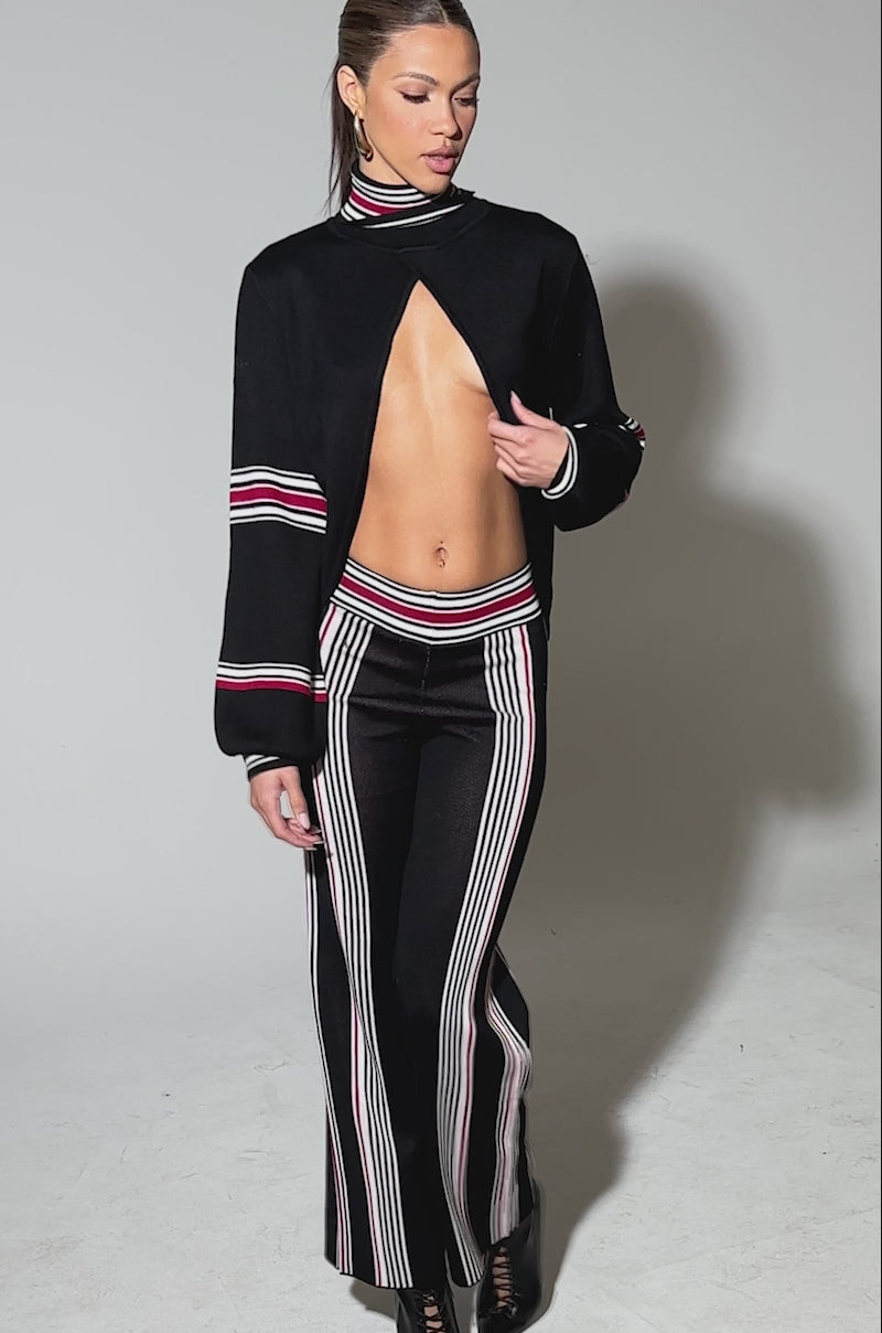 Video of woman modeling the  KENDALL SWEATER WIDE LEG PANT, which features bold white and red vertical stripes.