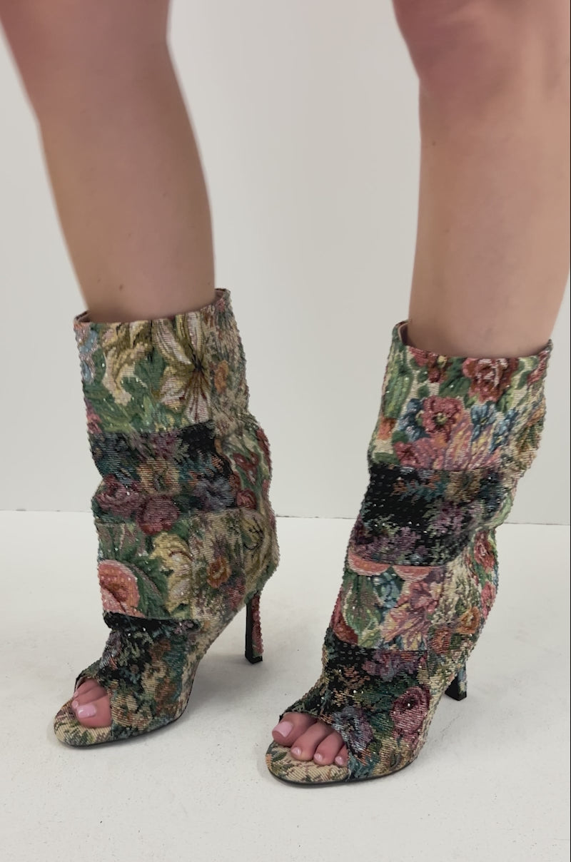 Video of person modeling the AZALEA WANG JONICE Floral Rhinestone Embellished Open Toe Bootie, featuring a colorful floral tapestry pattern, ankle-high fit, and light pink toenails visible through the open toe