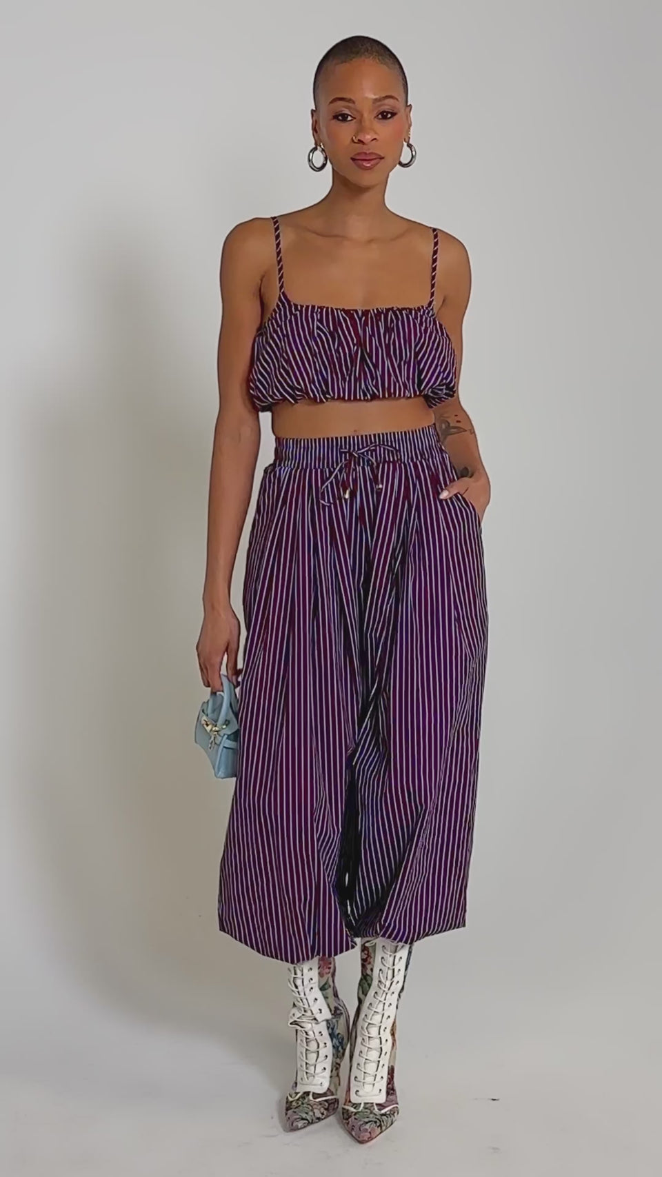Video of woman modeling the COULD BE DIFF BRALETTE in maroon and blue stripes, paired with matching high-waisted pants