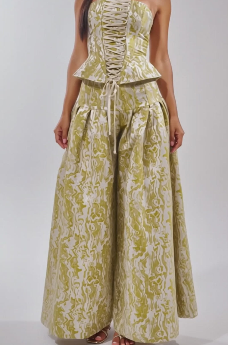 Video of woman modeling the GET IT FLORAL CORSET with lace-up detailing and a matching flared pant—an eye-catching choice for bold brunch looks—while standing against a plain light background.