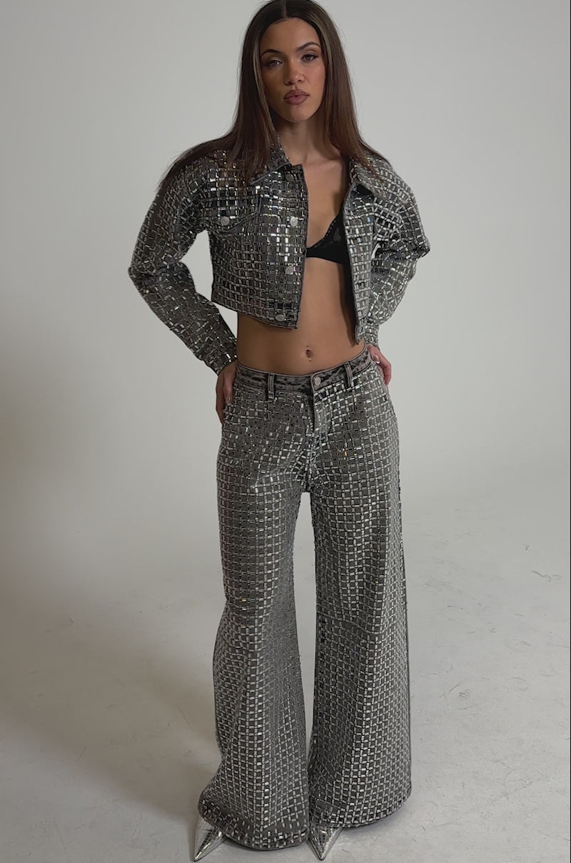 Video of woman modeling the PICK N CHOOSE RHINESTONE WIDE LEG DENIM IN GREY, paired with a matching silver sequin jacket against a plain, light background.