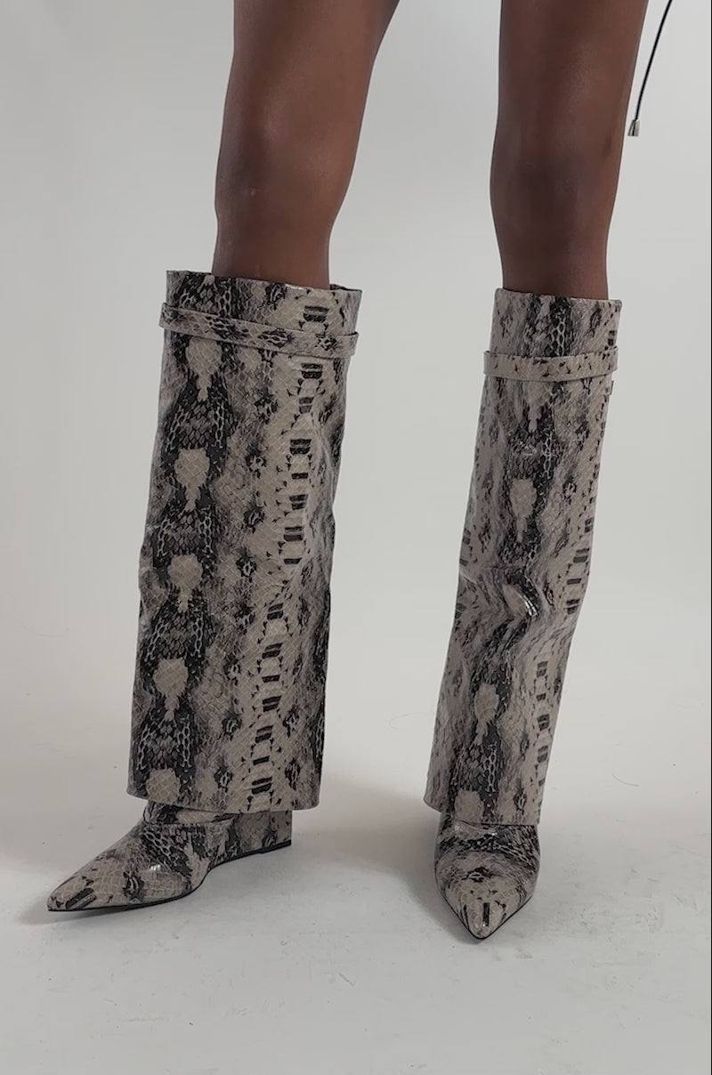 Video of a woman modeling the AZALEA WANG ENZO GREY SNAKE SHARK BOOT—tall, trendy wedge-heeled boots in snakeskin faux leather.