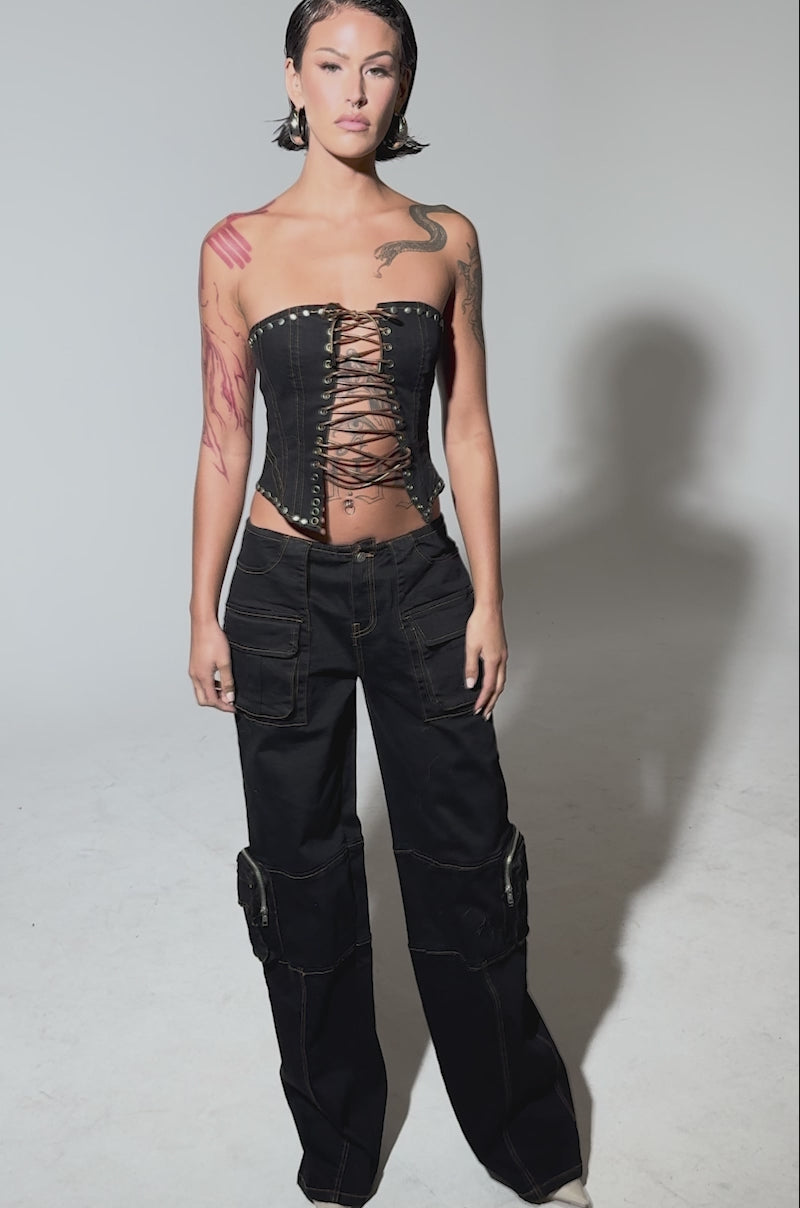 Video of woman modeling the FEELING FRISKY CARGO DENIM PANT—high-waisted, black, wide-leg with brown stitching—paired with a cropped black top.