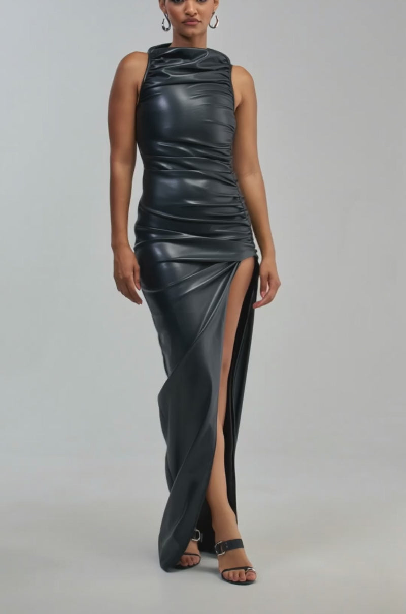 Video of a woman modeling the DATE NIGHT NEEDED PU MAXI DRESS IN BLACK, a sleeveless faux leather maxi dress featuring a high slit that reveals one leg. 