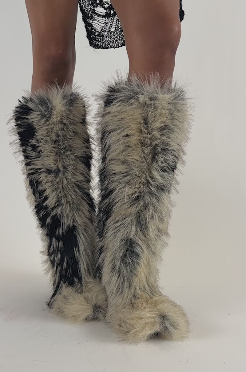 Video of a woman modeling the AZALEA WANG UPSTARTER BEIGE MULTI STILETTO FUR BOOTS, which feature shaggy black and beige faux fur.