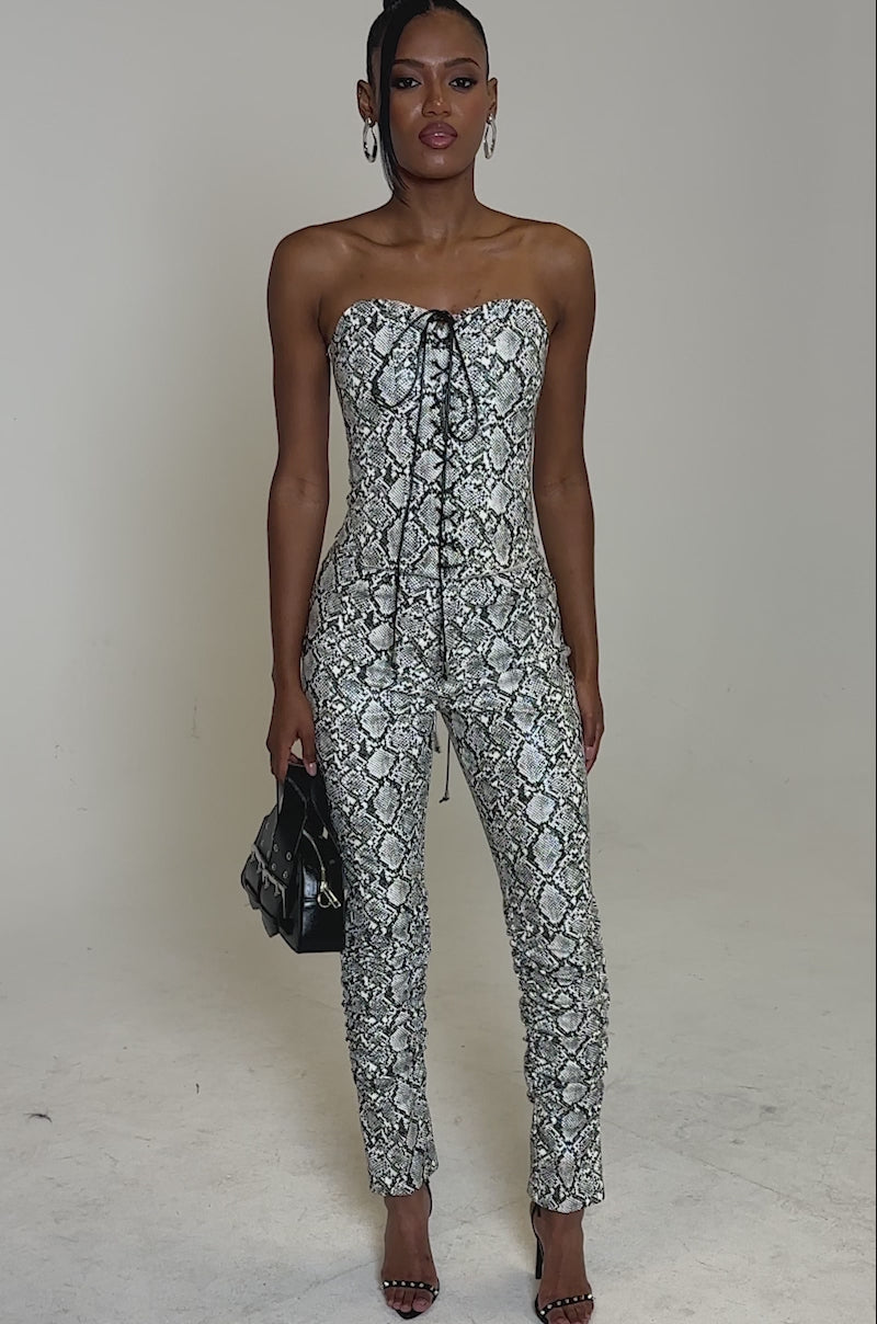 Video of woman modeling the SNEAKY LITTLE SNAKE CORSET, a strapless black-and-white faux snakeskin dress with a lace-up front, styled with matching pants
