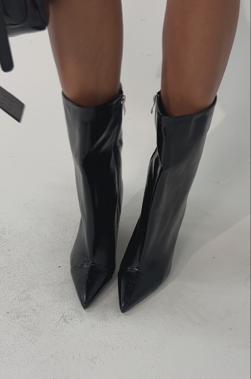 Video of woman modeling the AZALEA WANG VINCI BLACK PU PRINT WEDGE BOOTIE with pointed toes and side zippers, paired with a black textured handbag detailed with silver studs and hardware.