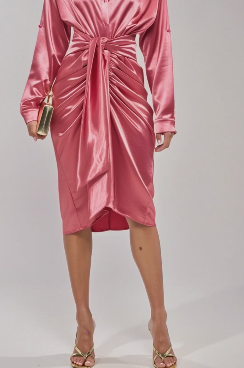 A video of a woman wearing the WITH LOVE COLLARED SATIN MIDI DRESS, a shiny rose-colored satin midi with long sleeves, collared neckline, and gathered waist knot. 