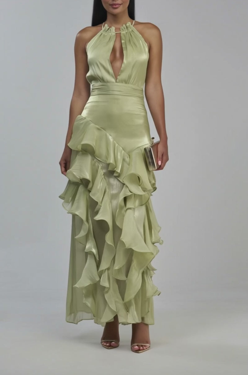 Video of a woman modeling the HONORABLE MENTIONS CHIFFON MAXI DRESS IN SAGE—a light green, halter-neck gown with a plunging neckline and a ruffled, layered skirt.