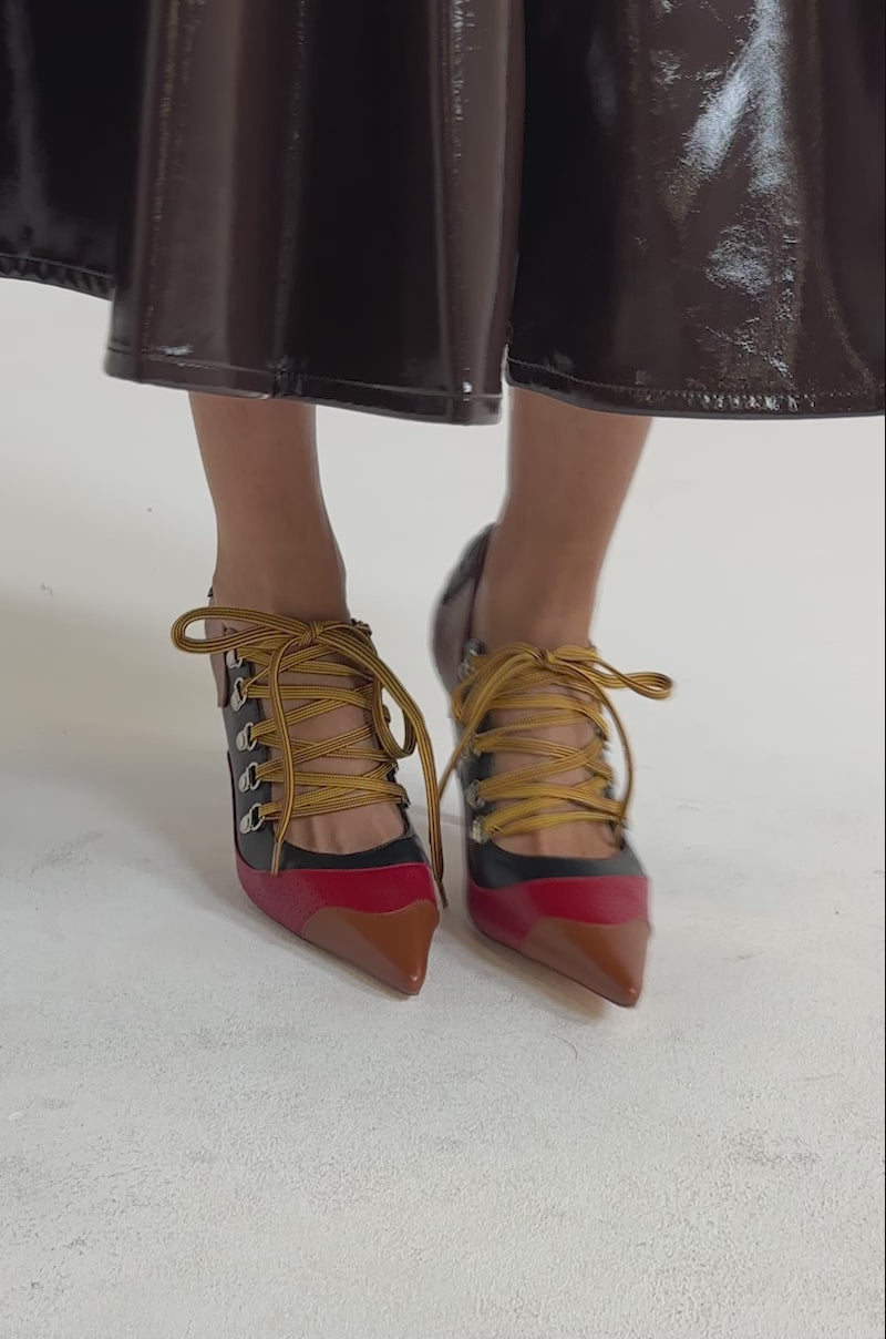 A video of a model wearing a shiny brown midi skirt and AZALEA WANG BLITZ RED MULTI SPORTY PUMP heels.
