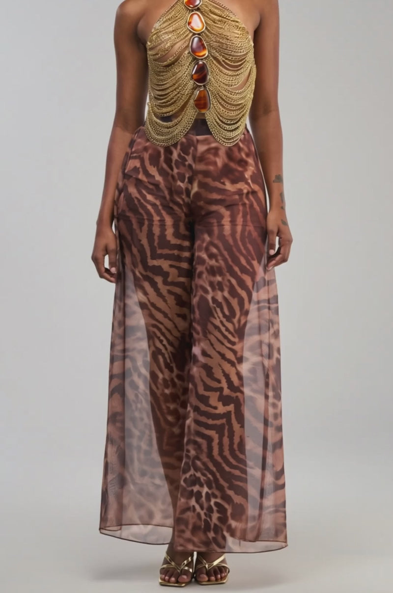 Video of a woman modeling the ALL EYES ON ME CHAIN TOP—a gold chain halter adorned with amber-like stones.