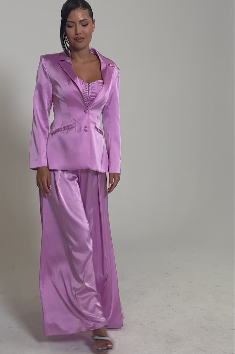 Video of woman modeling the IN FULL BLOOM LIGHT PURPLE BLAZER and wide-leg trousers stands against a plain light background