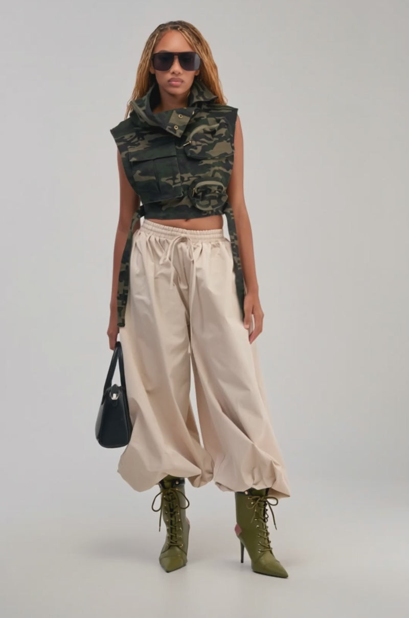 Video of a woman modeling the KADEN CARGO SLEEVELESS TOP IN CAMO styled as a streetwear utility vest with large pockets.