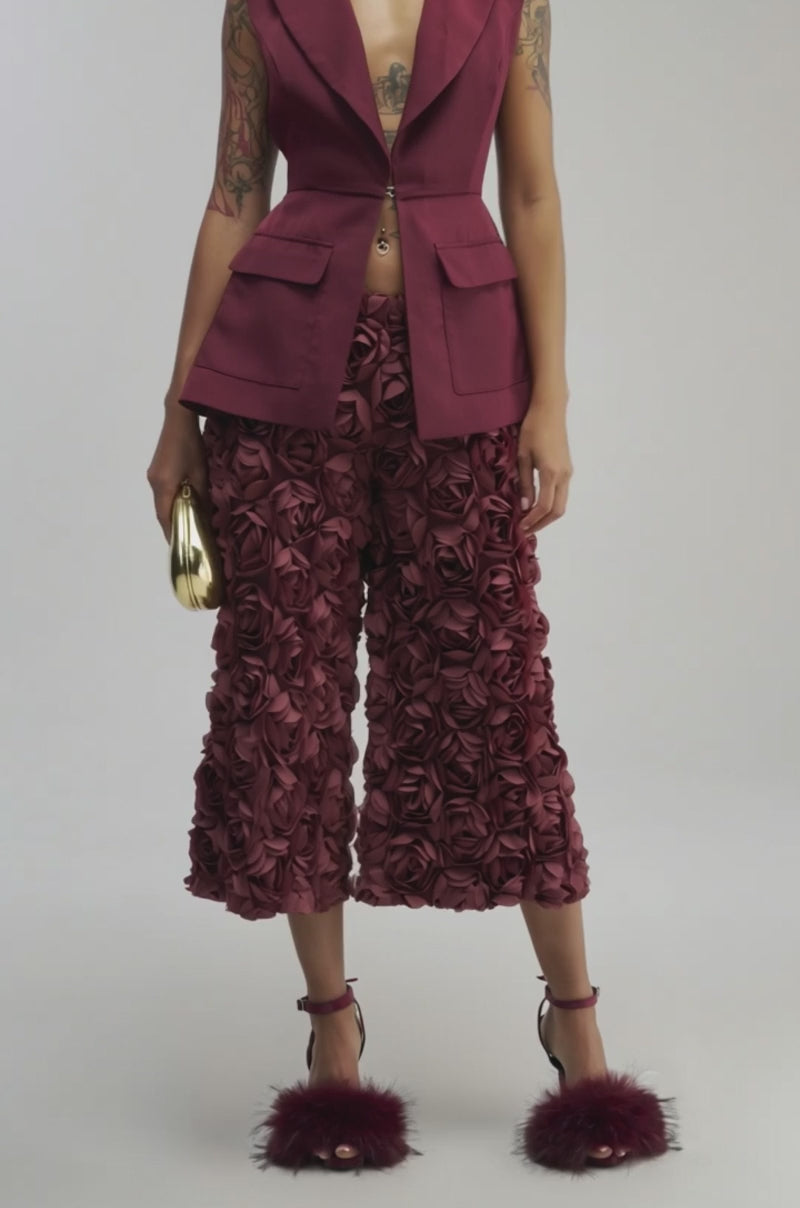 Video of a woman modeling the NAOMI BLAZER VEST IN BURGUNDY— a sleeveless blazer with front pockets and a gold clasp.