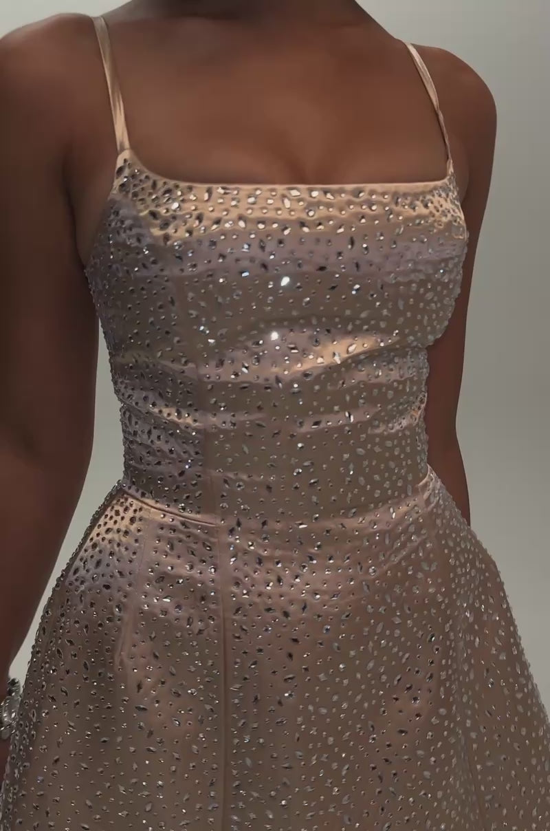 Video of a woman modeling the SAY HELLO RHINESTONE CORSET MINI DRESS, a sleeveless, light pink mini dress embellished with sparkling rhinestones. 