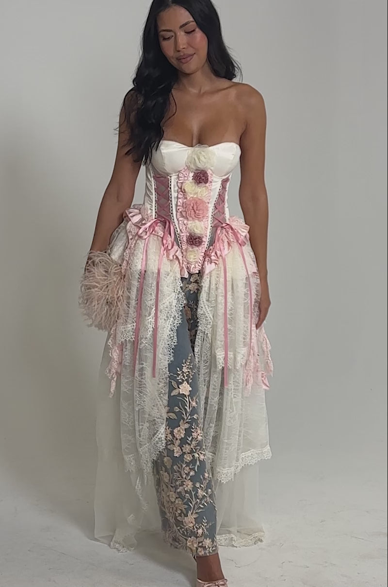 Video of woman modeling the FLY AWAY CORSET, a white satin princess-style top with pink floral details