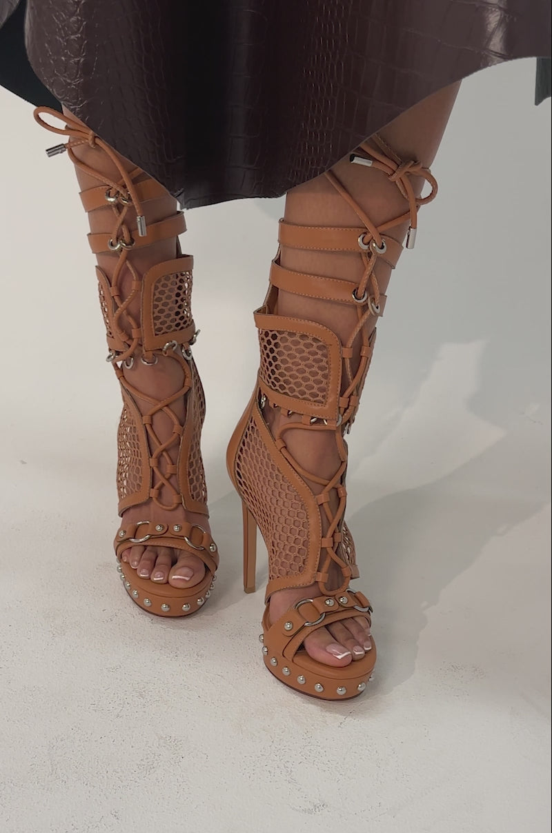Video of woman modeling the AZALEA WANG ISARIA Tan Stud Embellished Gladiator Platform Stiletto heels with mesh panels on a light-colored surface.