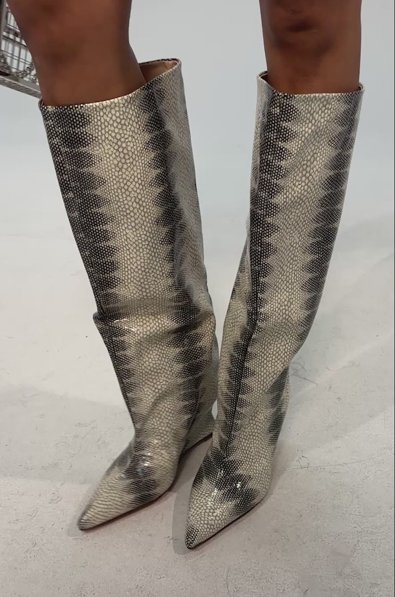 Video of woman modeling the AZALEA WANG BRUN GREY SNAKE WEDGE BOOT and a textured olive dress