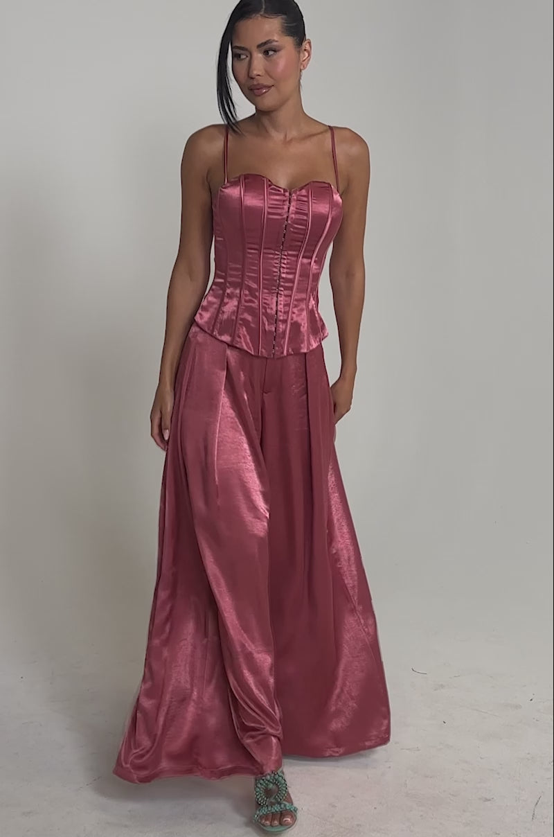 Video of woman modeling the IN FULL BLOOM CORSET IN MAUVE, a shiny satin top with a sweetheart neckline and thin straps, paired with a matching pant.