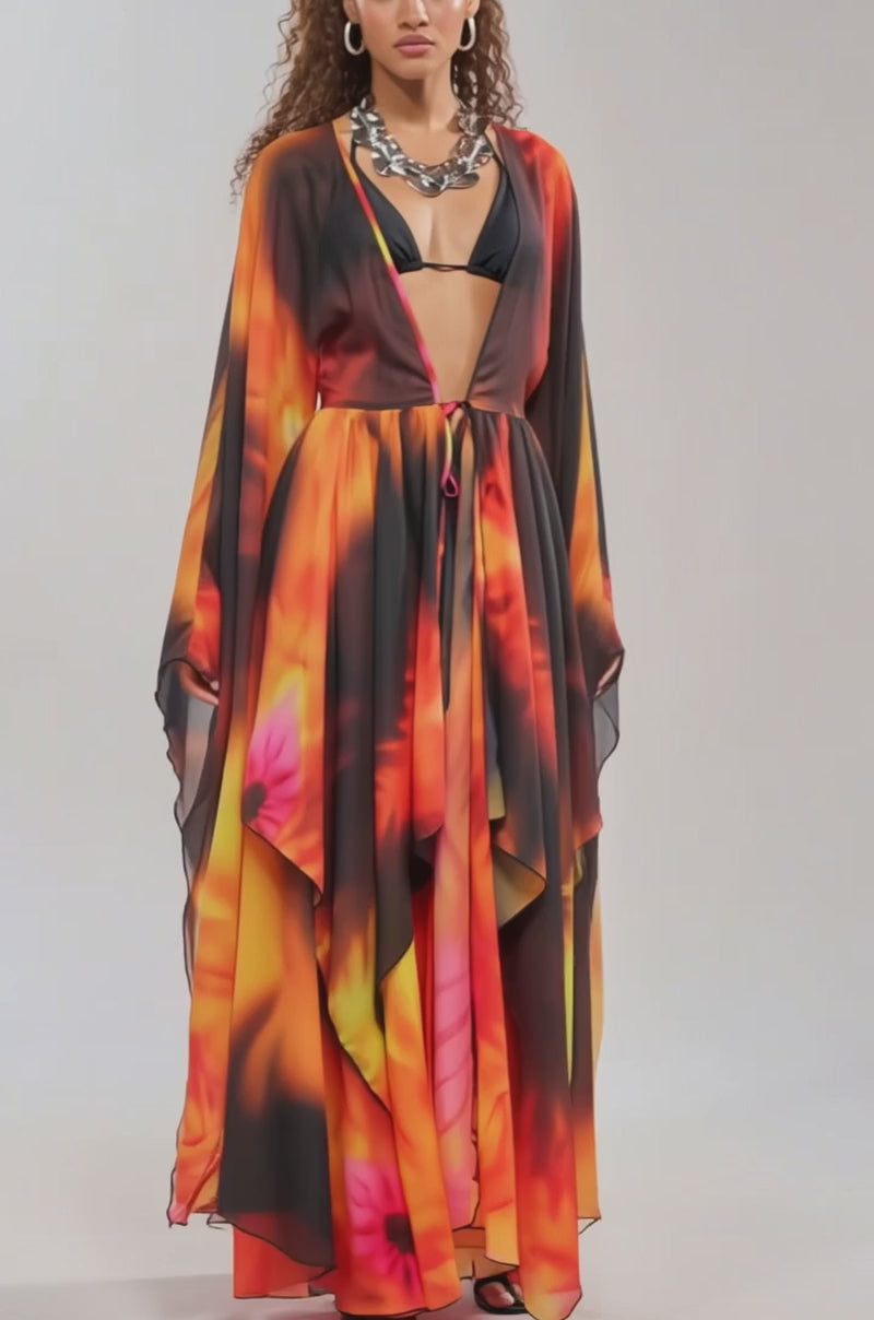 Video of woman modeling the GIRL ON FIRE CHIFFON CARDIGAN, a vibrant sheer floral print in orange, red, and yellow, styled over a black bikini top and shorts against a plain background.