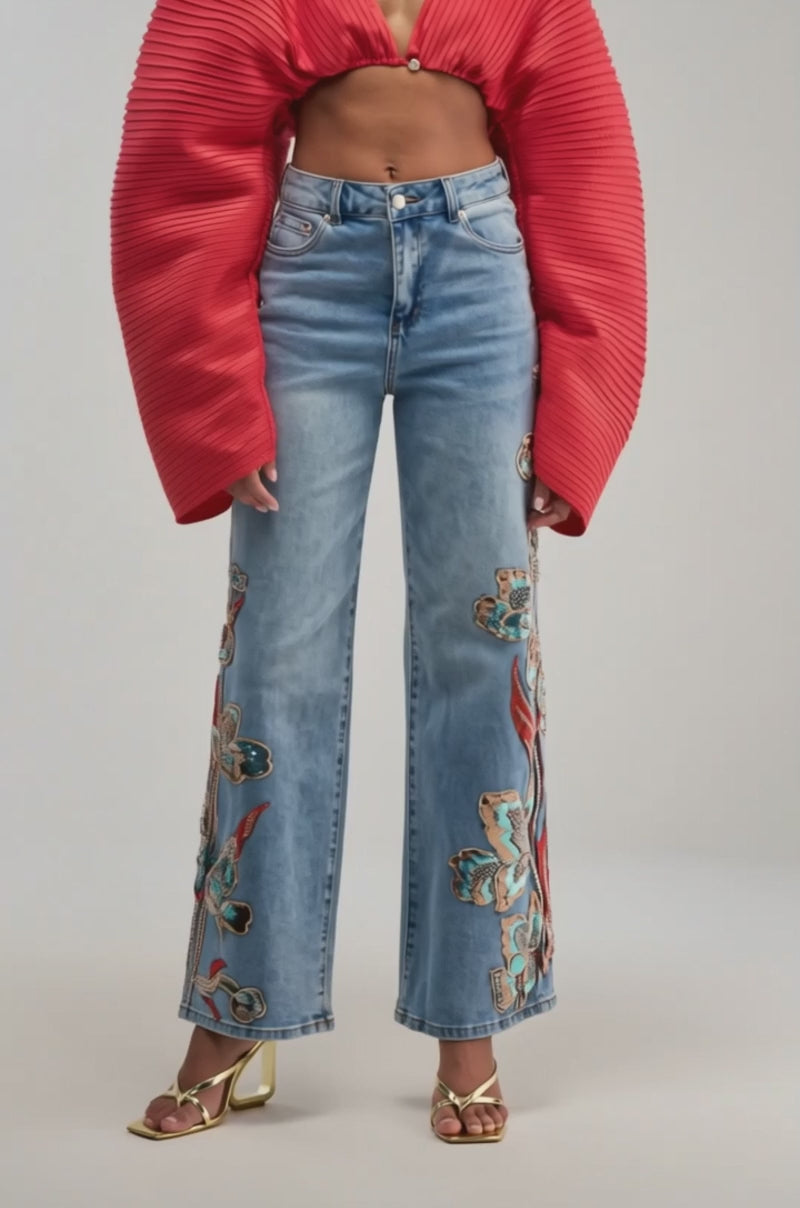 Video of a woman modeling the FIANA LONG SLEEVE BLOUSE featuring pleated red fabric and wide, balloon sleeves.
