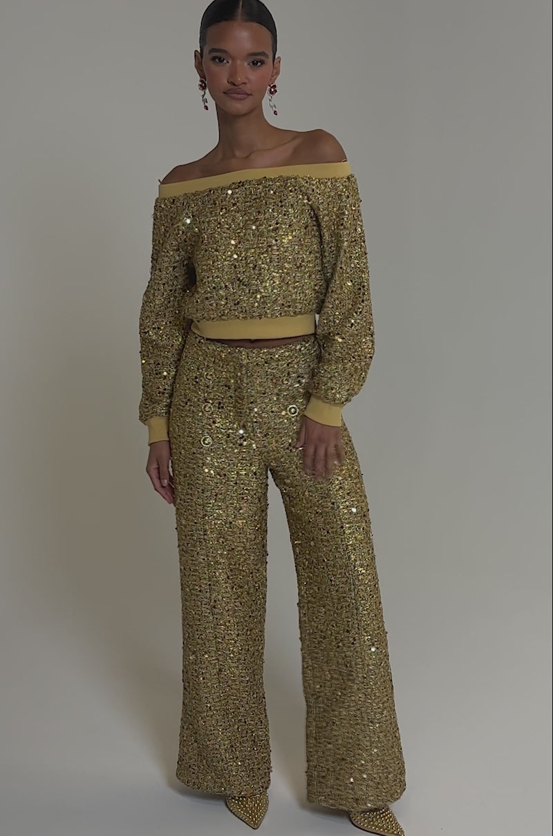 Video of woman modeling the PRETTY IN GOLD STRAIGHT LEG PANT and a matching off-the-shoulder gold sequin top, paired with pointed gold shoes.