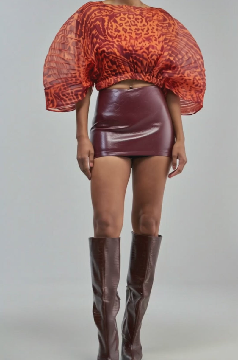 Video of a woman modeling the WILDFIRE ENERGY CHIFFON TOP—a sheer, orange animal print blouse with puffed sleeves.