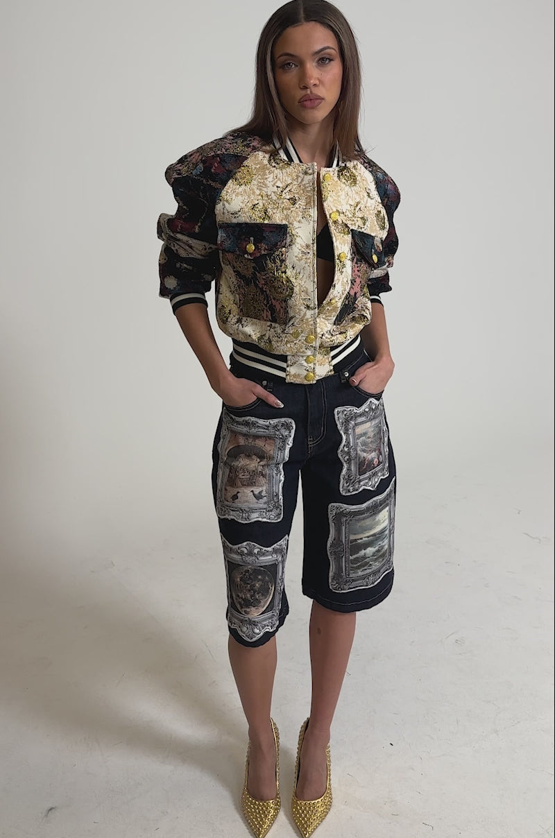 Video of woman modeling the EGO CHECK PATCHWORK BOMBER paired with dark jean shorts featuring bold framed painting prints.