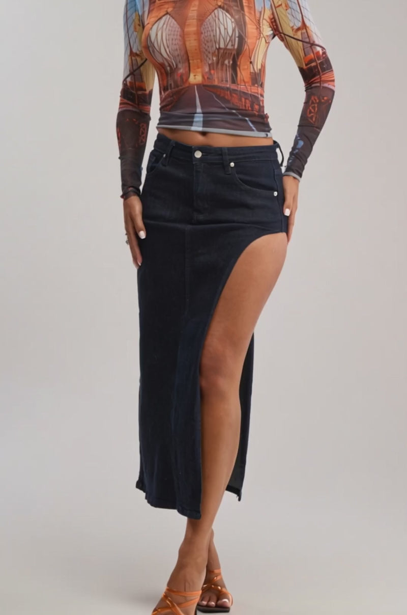 Video of woman modeling the ROADTRIP MESH LONG SLEEVE TOP with a Brooklyn Bridge graphic, styled for a summer date night with a high-slit dark denim skirt, hoop earrings, and slicked-back hair against a plain background.