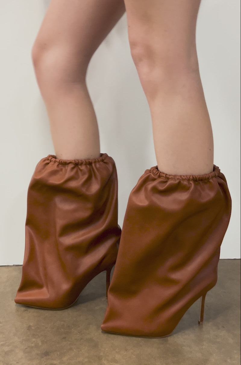 Video of person modeling the AZALEA WANG ANNEKE Tan Ruched Topline Stiletto Bootie featuring smooth brown leather, a loose ruched design, pointed toe, and thin stiletto heel for chic, modern style.