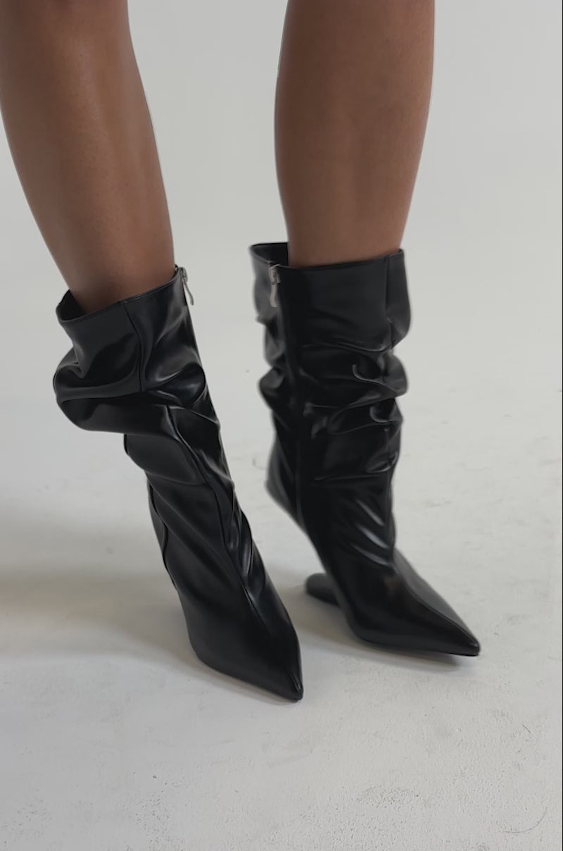 A video of a person wearing  the AZALEA WANG DRISANA Black Slouchy Invisible Wedge Cocktail Bootie.