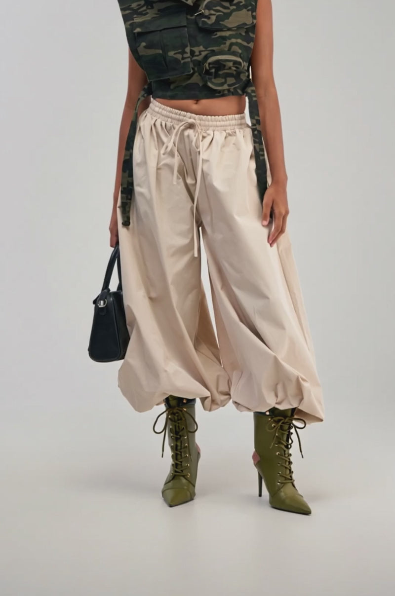 Video of a woman modeling the GUESS WHO BALLOON PANT—relaxed, high-rise, and beige with a drawstring waist.
