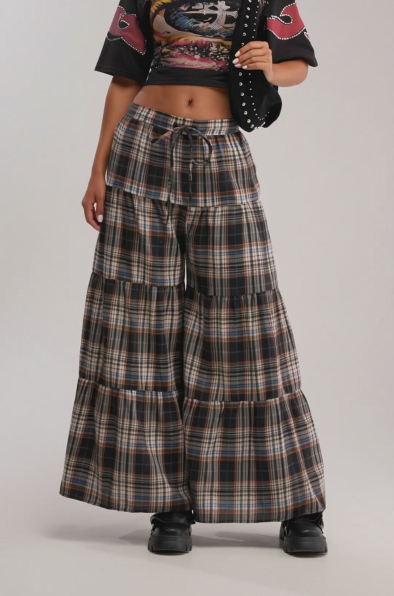 Video of woman modeling the DOWN FOR A LITTLE FUN PLAID PANT, a high-rise, wide-leg cotton-blend style in black, brown, and white plaid, paired with black chunky shoes. 