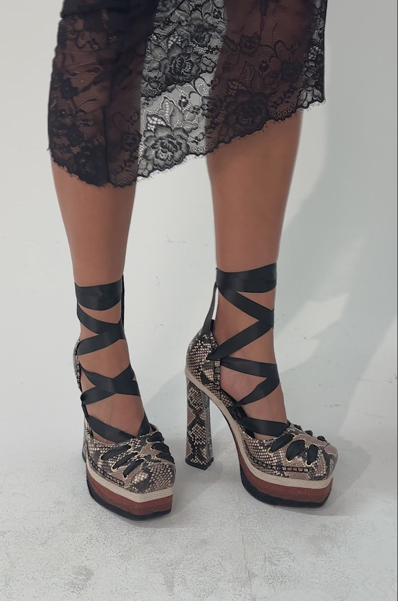 A video of a person wearing the AZALEA WANG FONTEYN SNAKE PLATFORM PUMP.