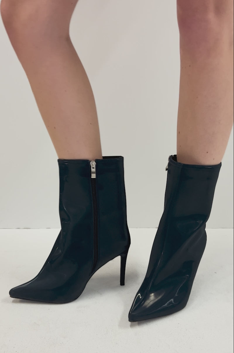 Video of person modeling the AZALEA WANG QUINNTA NAVY BOOTIE, featuring shiny navy high heels with pointed toes and a reflective shine.