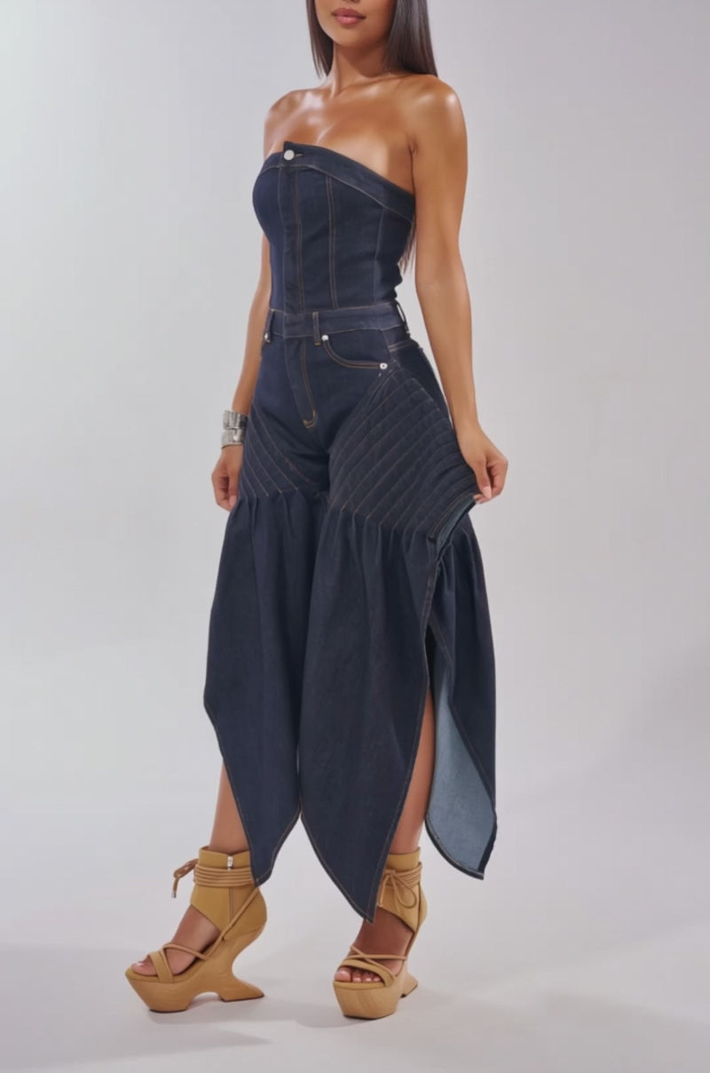 A video of a woman wearing the NO ONE LIKE ME DENIM ROMPER IN DARK BLUE DENIM, a strapless jumpsuit with exaggerated hip detailing and flared panels.