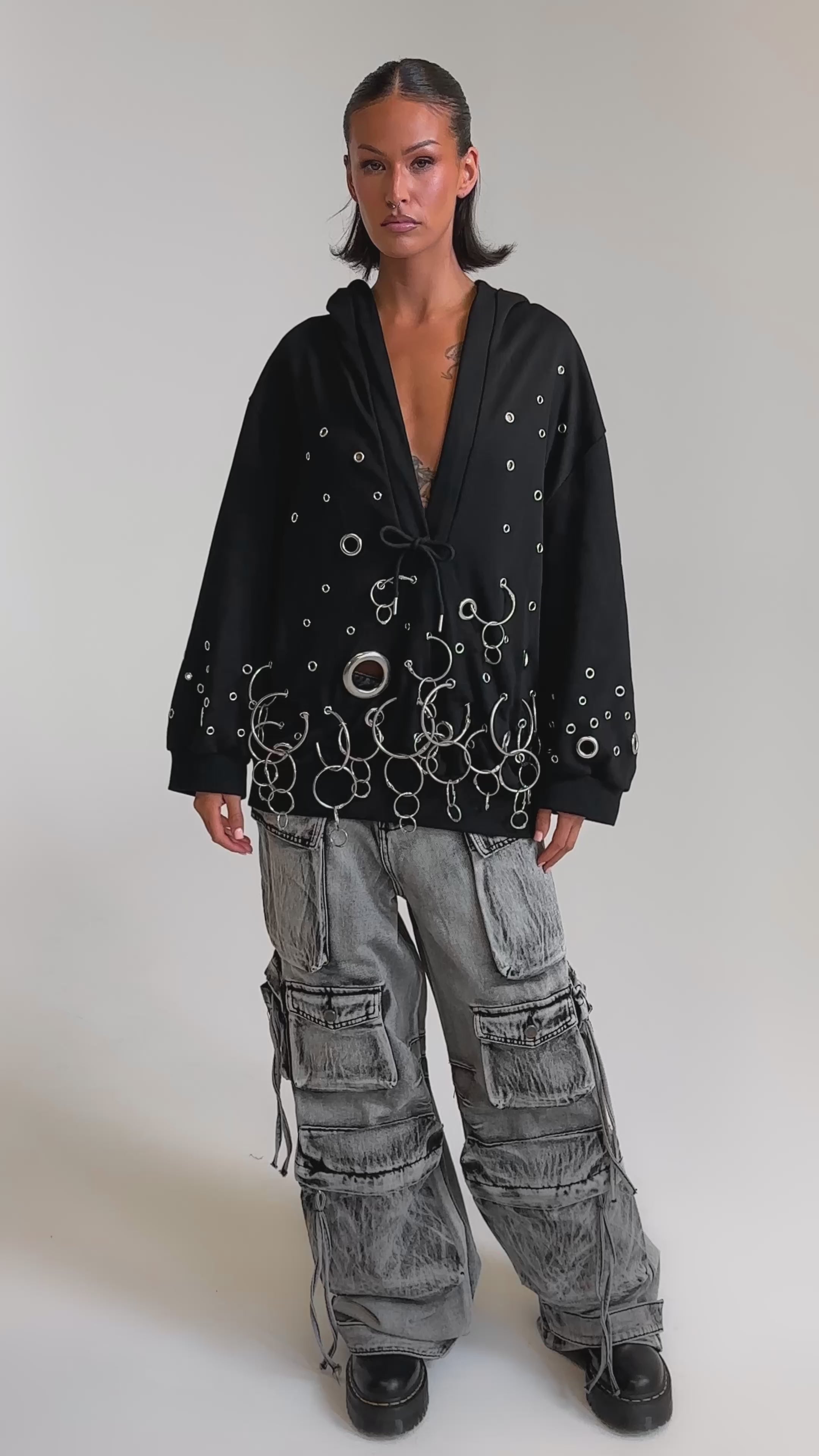 A video of a woman in an oversized black hoodie and chunky shoes, paired with the CARGO FOR DAYS CARGO DENIM PANT featuring drawstrings and multiple pockets.