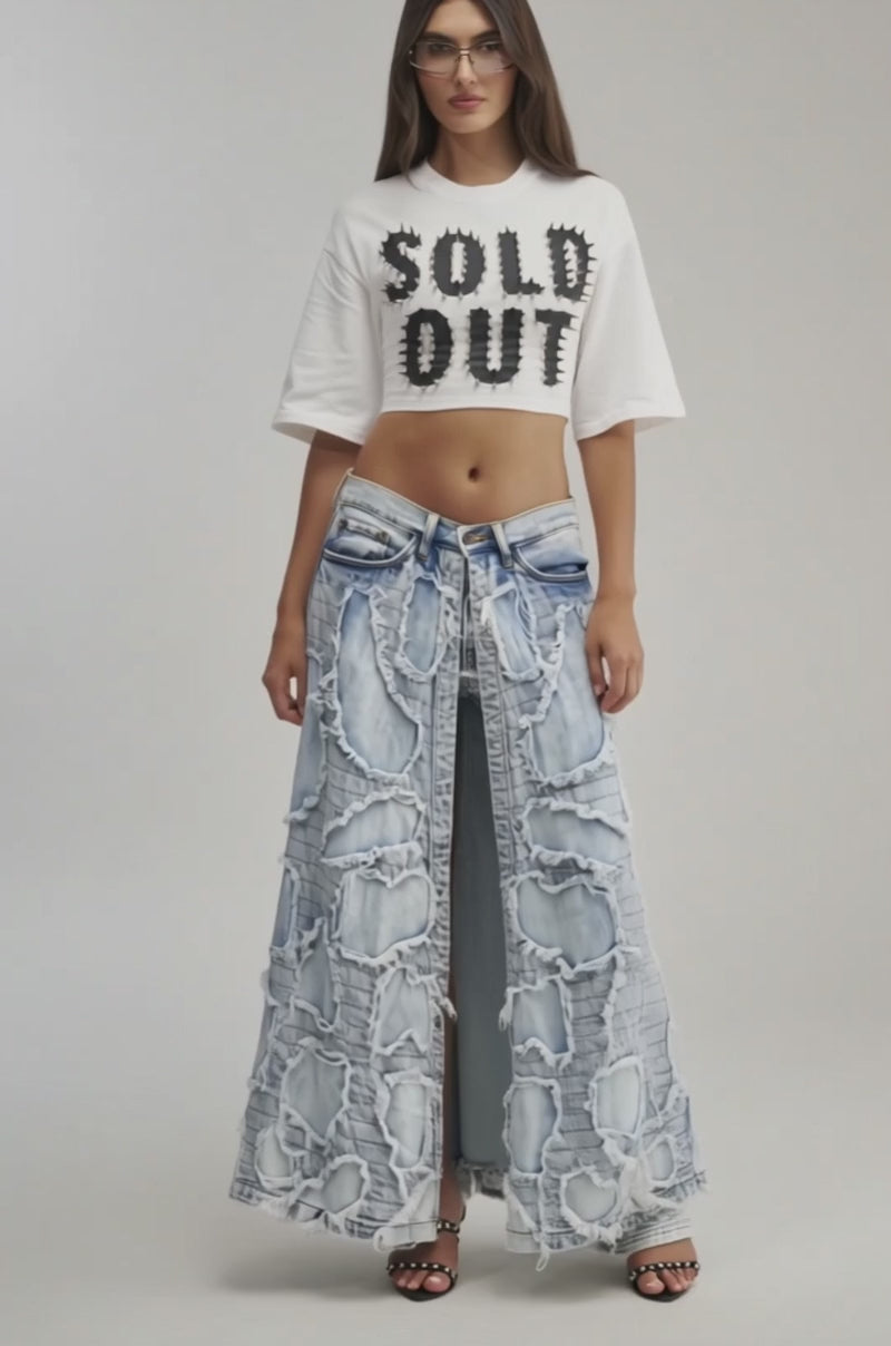 Video of a woman modeling the SOLD OUT CROPPED TEE and high-waisted, distressed blue jeans.