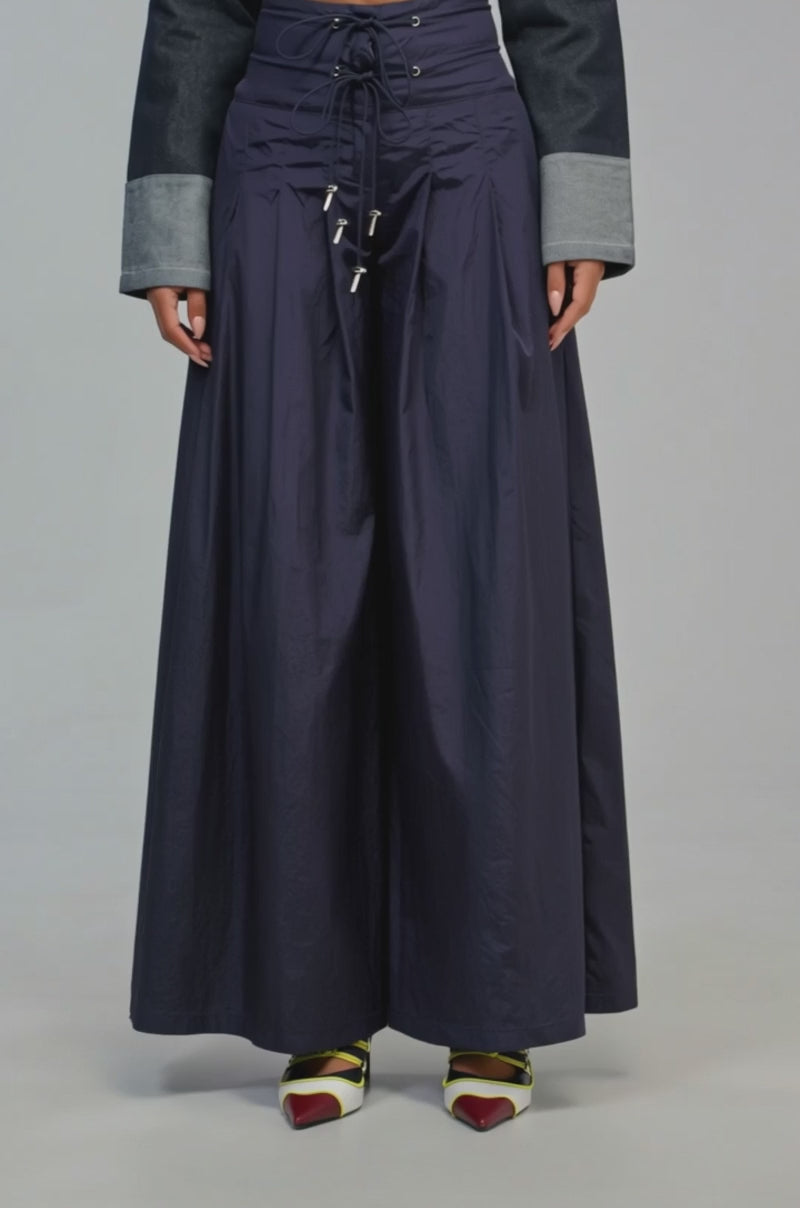 Video of a woman modeling the DANCE THE NIGHT AWAY PALAZZO PANT IN NAVY, which features a wide-leg silhouette with a lace-up front.