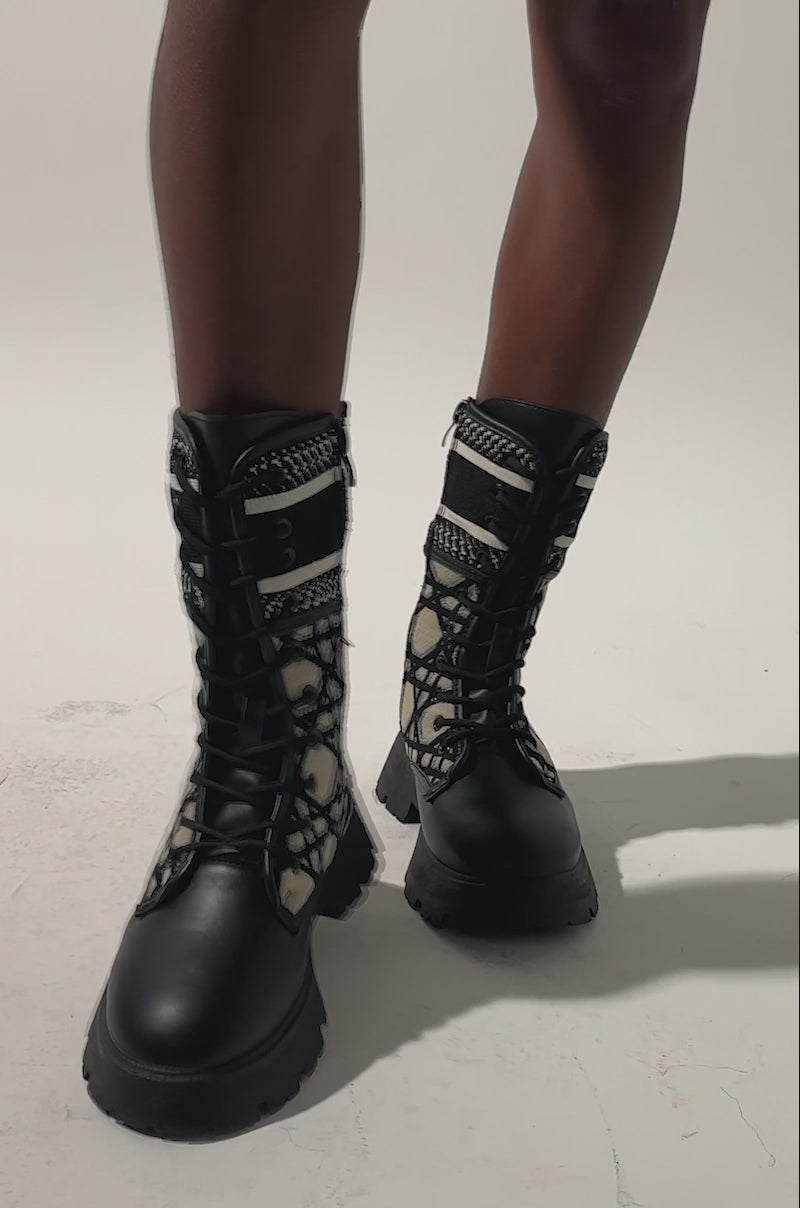 A video of a wearing a tan skirt and AMADA CANVAS PRINT COMBAT BOOT.