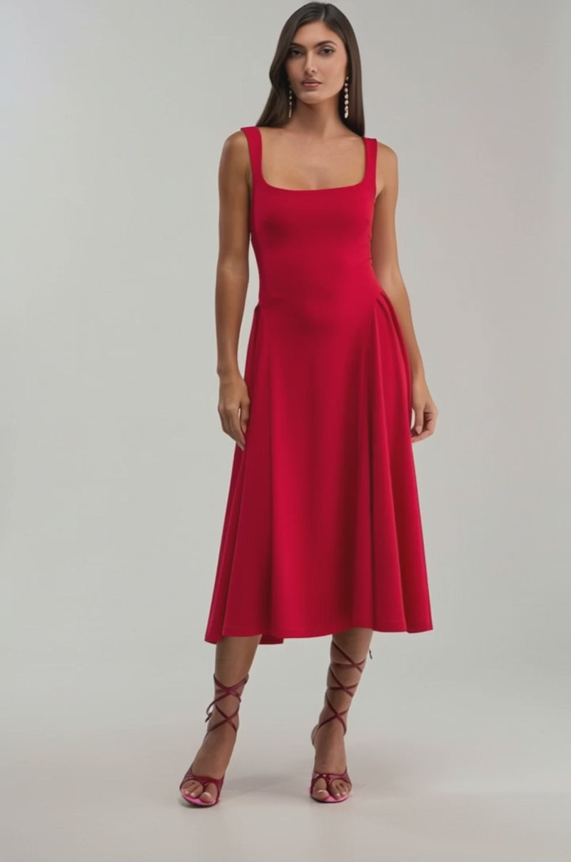 A video of a woman wearing the BOSS BABE MIDI DRESS, a sleeveless red fit-and-flare midi dress with a fitted bodice and flared skirt, styled with strappy high-heeled sandals.