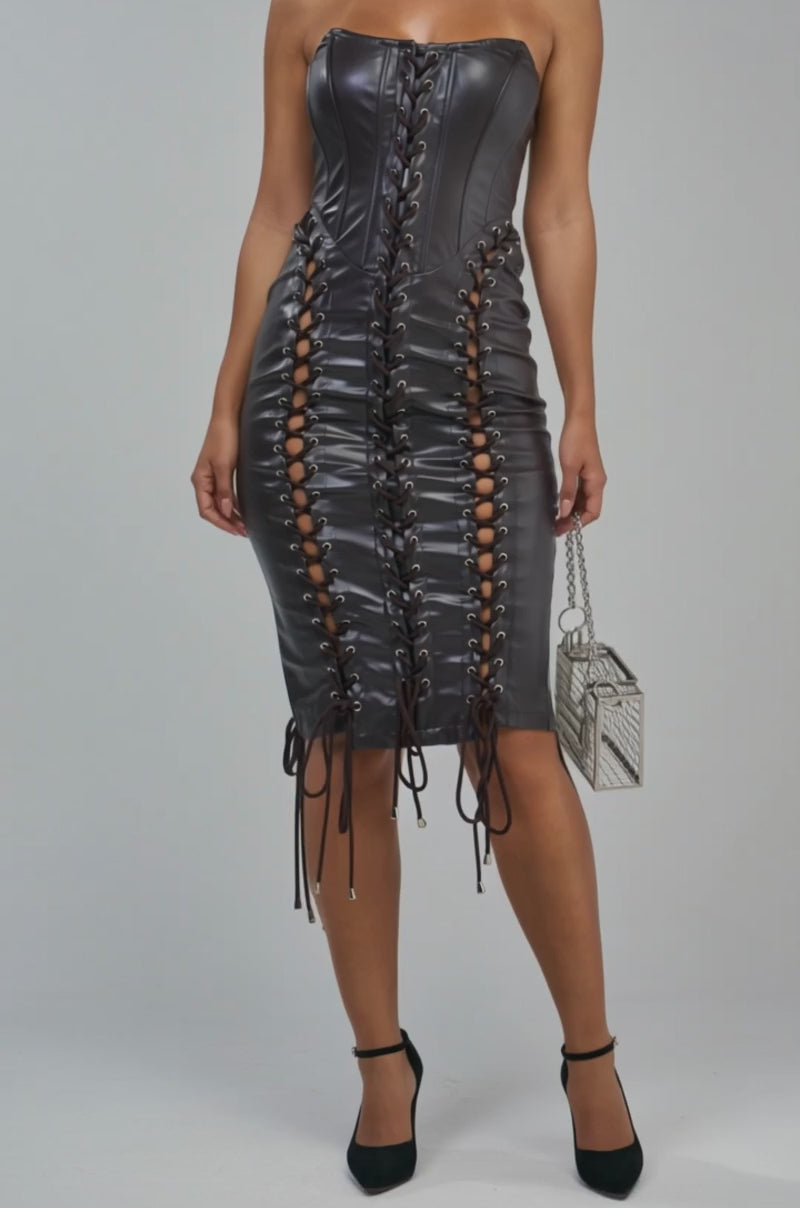 Video of a woman modeling the SIN CITY Lace Up PU Midi Dress in brown, featuring a strapless design and side cutouts.