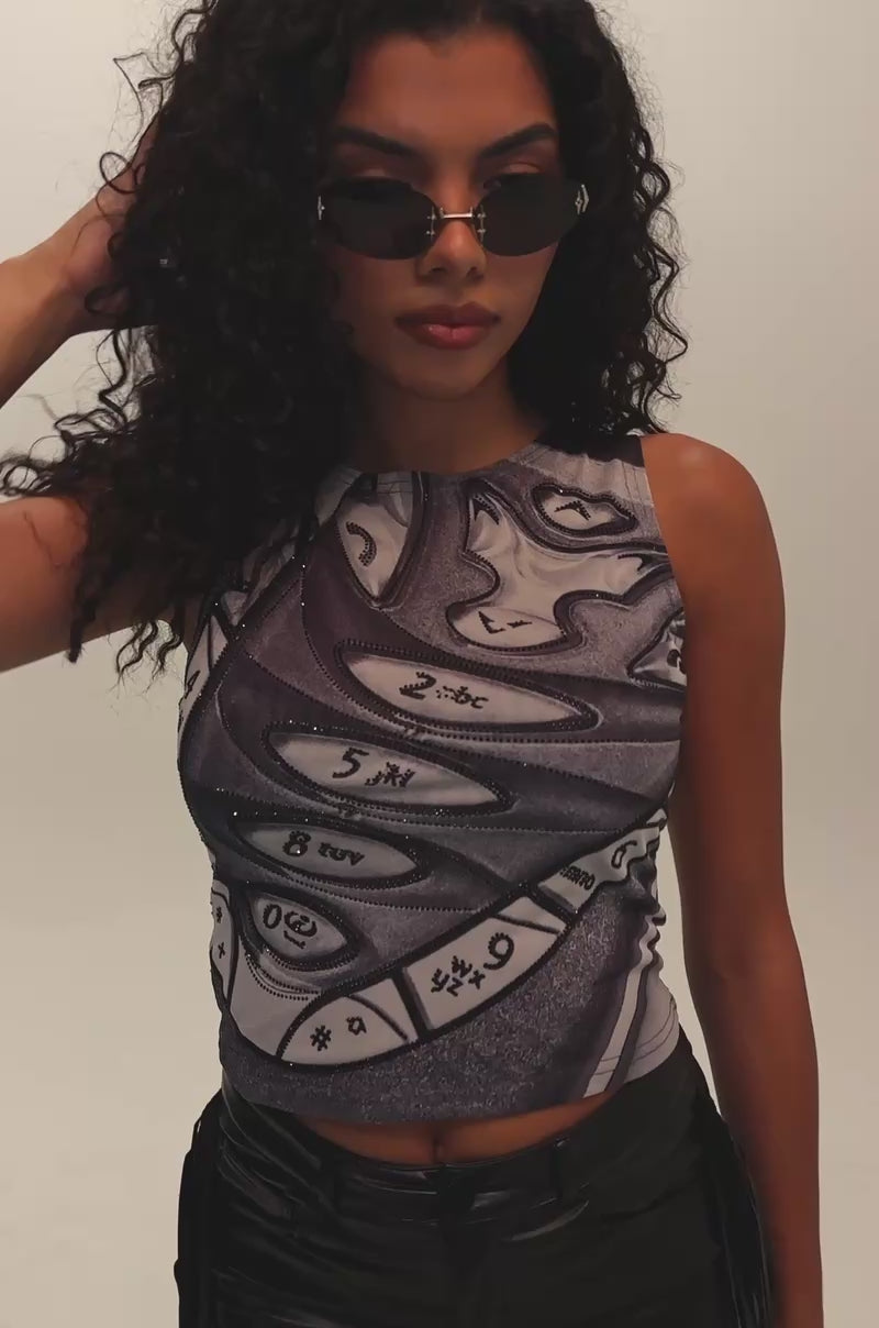 Video of a woman modeling the CHECK THIS OUT MESH TANK IN GREY—a sleeveless graphic top featuring abstract numeric designs.