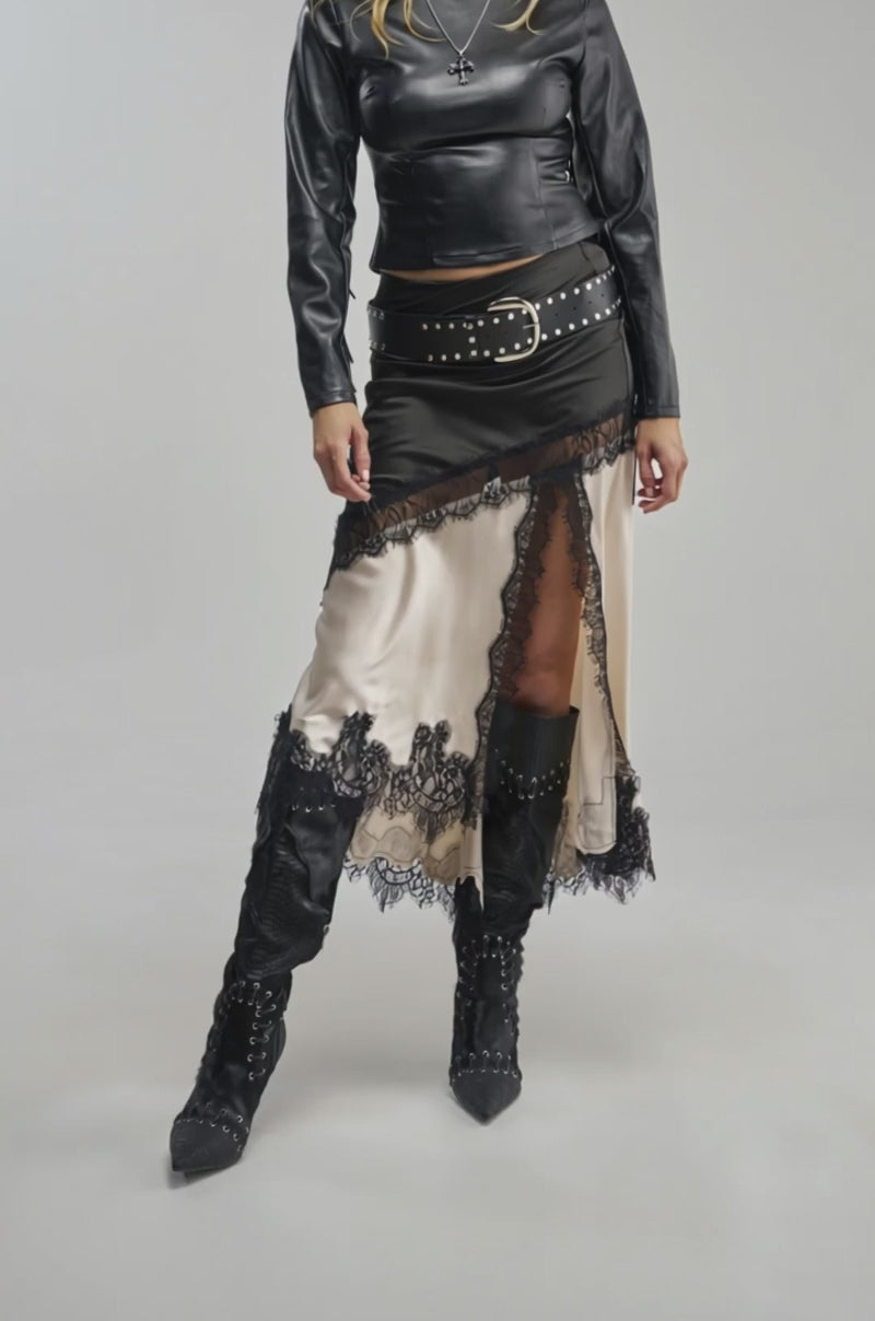 Video of a woman modeling the SHINE BRIGHT SATIN MIDI SKIRT—featuring cream and black lace trim and a sheer lace-paneled side slit. 