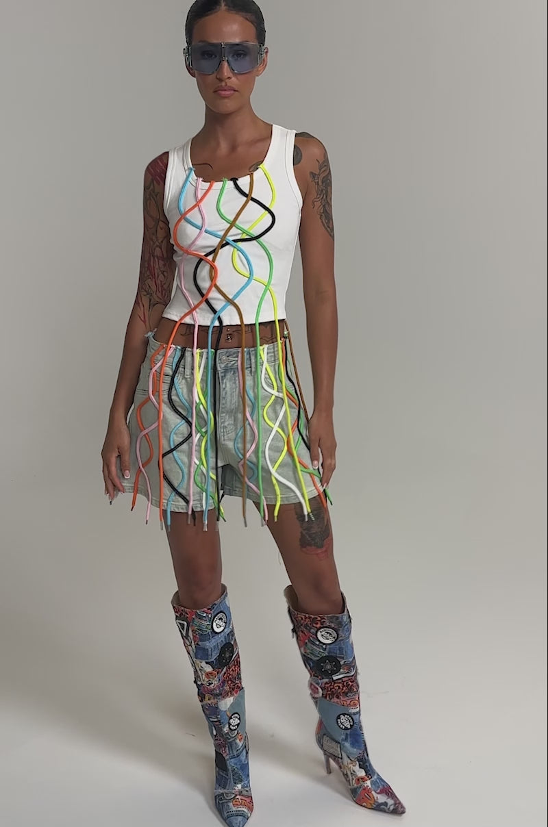 Video of woman modeling the CRAZY FOR YOU DENIM SHORT with rainbow laces and vibrant boots, this look channels festival streetwear. 