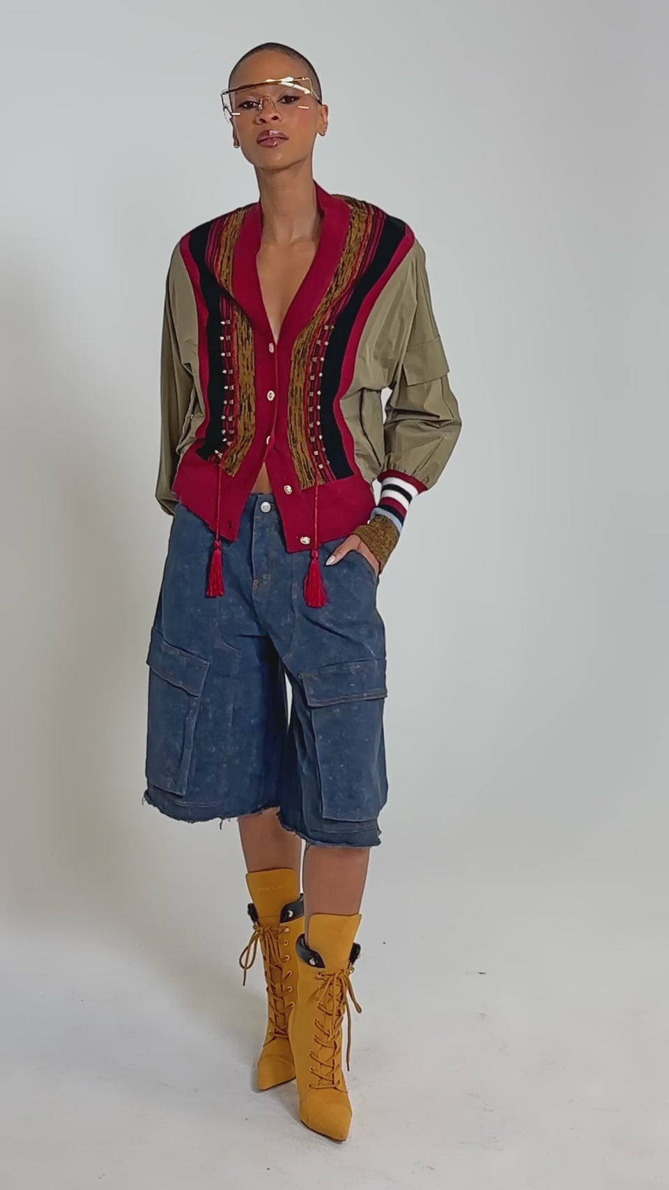 Video of woman modeling the NEW DAY COLORBLOCK CARDIGAN, featuring red, navy, and tan patterns, over a brown shirt and blue pants. 